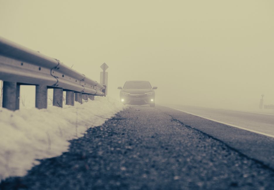 Hazards of driving in foggy snowy conditions with limited visibility.